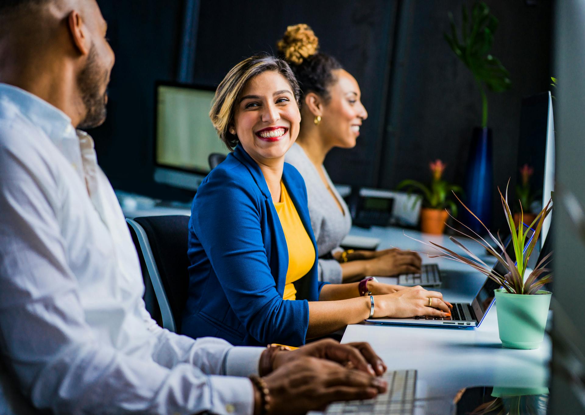A woman smiling at a coworker | Source: Pexels