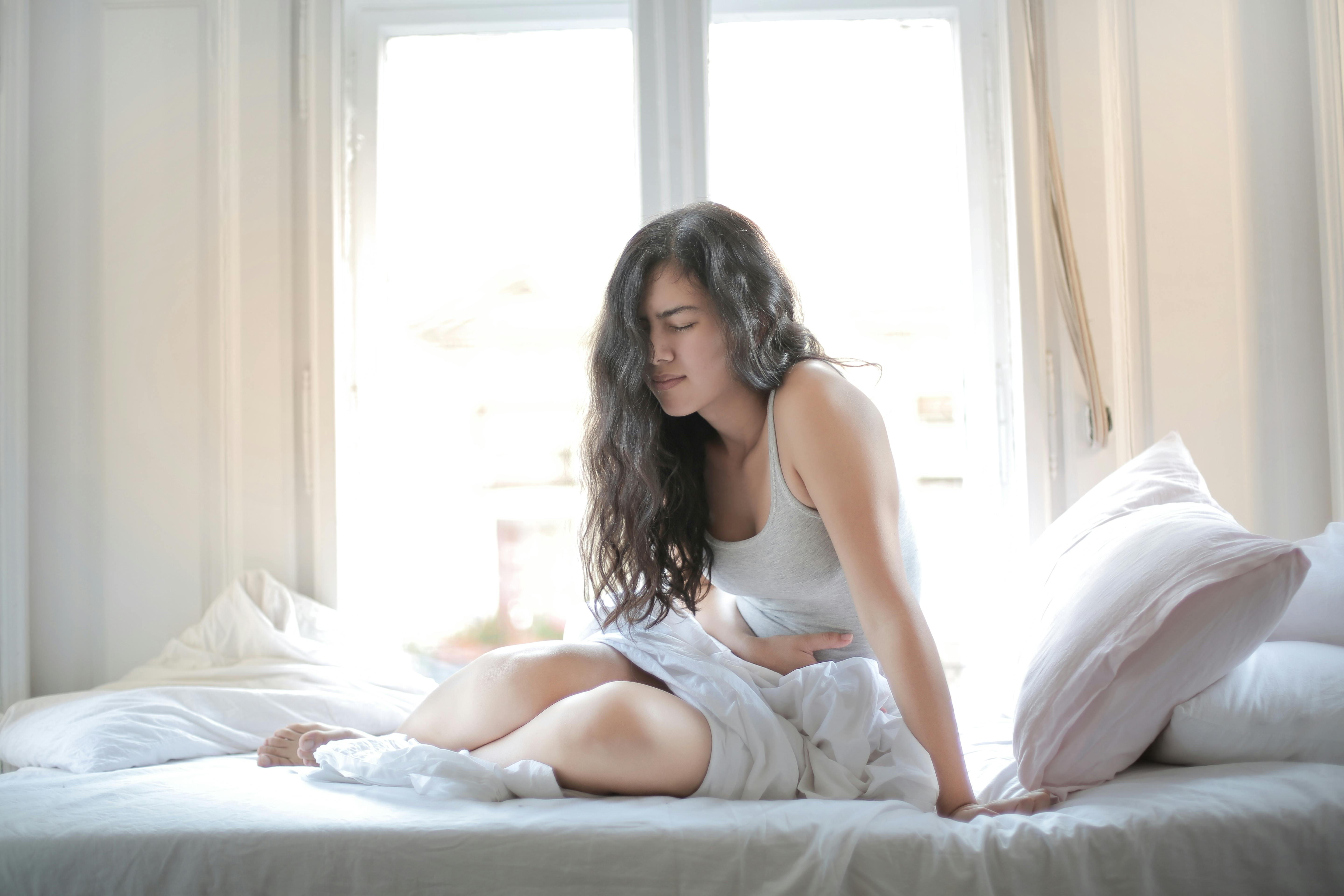 Woman with hand on her stomach | Source: Pexels